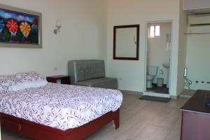 een slaapkamer met een bed en een stoel erin bij OceanSide Hotel & Pool in Bayahibe