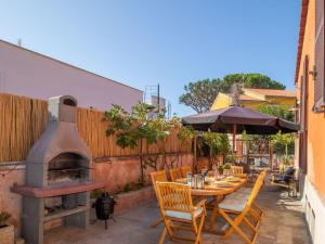a patio with a table and an outdoor oven at Villa Randi by Interhome in Anzio