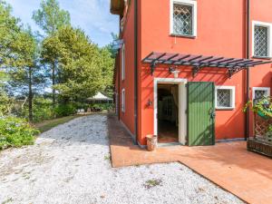 una casa naranja con una puerta verde y un camino de entrada en Holiday Home Casale il Poggio by Interhome, en Fucecchio