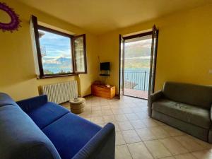 un soggiorno con divano blu e finestra di Apartment by Interhome a Dorio