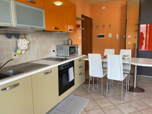 una cucina con tavolo e sedie bianche di Apartment by Interhome a Dorio