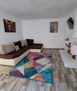 a living room with a couch and a colorful rug at Apartament Diaconu Coresi (Piata Sfatului) in Braşov