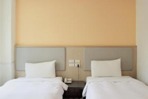 嘉義市的住宿－偶然行旅，两张睡床彼此相邻,位于一个房间里
