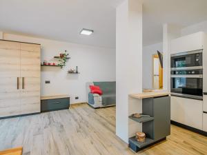 a living room with white walls and wooden floors at Apartment Enrosadira-9 by Interhome in Alba di Canazei