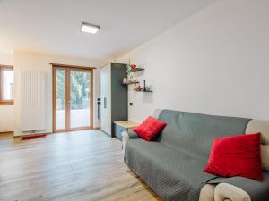 a living room with a gray couch and red pillows at Apartment Enrosadira-9 by Interhome in Alba di Canazei