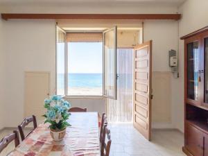 Un comedor con mesa y vista al mar. en Holiday Home Enrica by Interhome, en Marina di Mancaversa