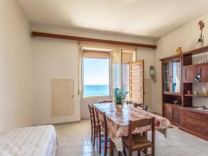 Un comedor con mesa y vista al mar. en Holiday Home Enrica by Interhome, en Marina di Mancaversa