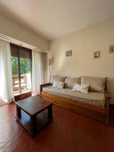 a bedroom with a large bed and a table at Pinamar departamento in Pinamar