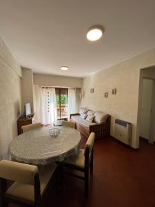 a living room with a table and a bed at Pinamar departamento in Pinamar