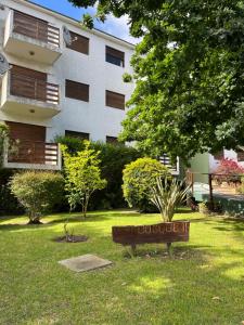 a sign in the grass in front of a building at Pinamar departamento in Pinamar