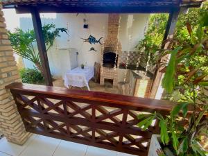 a balcony with a wooden fence and a table at Casa de Praia Em Aguas Belas 3 suites in Cascavel