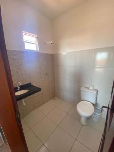 a bathroom with a toilet and a sink at Casa de Praia Em Aguas Belas 3 suites in Cascavel