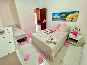 a room with a bed with pink balloons on the floor at Casa de Praia Em Aguas Belas 3 suites in Cascavel
