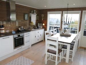 een keuken met witte kasten en een tafel met stoelen bij Holiday Home Bortebu - SOW139 by Interhome in Åseral