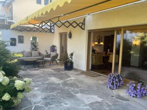 an outdoor patio with a table and purple flowers at Ferienhaus zur schönen Aussicht in Teisendorf +9 photos