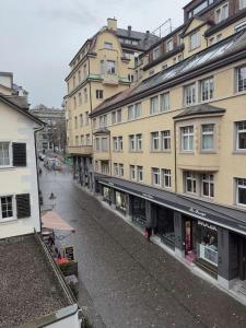 an empty street in front of tall buildings at Süsse Wohnung in Zürcher Altstadt 3 in Zürich