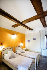 two beds in a room with wooden ceilings at Affittacamere famiglia Do in Racconigi