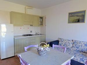 een woonkamer met een tafel en een keuken bij Apartment Borgo Valmarina-3 by Interhome in Carbonifera