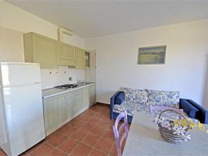 een keuken met een witte koelkast en een tafel met stoelen bij Apartment Borgo Valmarina-3 by Interhome in Carbonifera