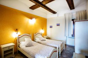 two beds in a room with yellow walls at Affittacamere famiglia Do in Racconigi +17 photos