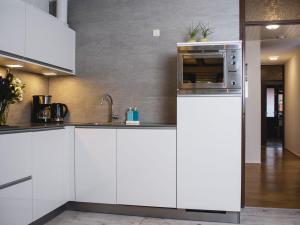 La cuisine est équipée de placards blancs et d'un four micro-ondes. dans l'établissement Apartment Delfzijl by Interhome, à Delfzijl
