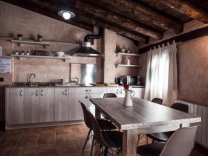 uma cozinha com uma mesa de madeira e cadeiras numa cozinha em AbenRazin Turístico Noguera em Albarracín