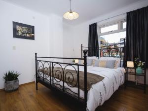 a bedroom with a black bed with a window at Apartment Delfzijl by Interhome in Delfzijl