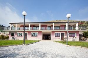 a pink house with two street lights in front of it at Villa Oasi in Gaeta