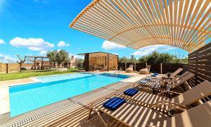 a large swimming pool with chairs and an umbrella at Cretan Sunrise Villa Heated Pool in Dhimitroulianá