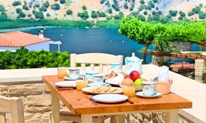 a table with food on it with a view of a lake at Cretan Sunrise Villa Heated Pool in Dhimitroulianá +29 photos