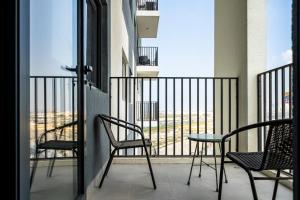 a balcony with two chairs and a table on a balcony at ALH Vacay - The Nook 1 - 2 Bedrooms - Near Metro in Dubai