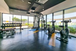 a gym with treadmills and elliptical machines and windows at ALH Vacay - The Nook 1 - 2 Bedrooms - Near Metro in Dubai