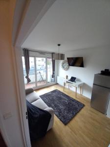 a living room with a couch and a table at COSY PARIS WITH BALCONY in Issy-les-Moulineaux