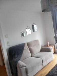 a living room with a couch and pictures on the wall at COSY PARIS WITH BALCONY in Issy-les-Moulineaux