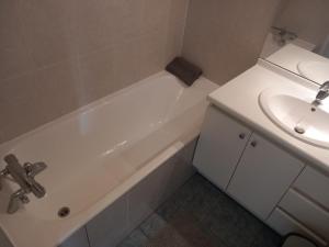 a bathroom with a sink and a white bath tub at COSY PARIS WITH BALCONY in Issy-les-Moulineaux