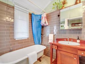 a bathroom with a tub and a sink at Historic Character-filled Jade Cottage in Coalfalls