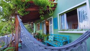 a porch with a hammock outside of a house at Casa de Mar - Praia do Sagi in Baía Formosa +47 photos