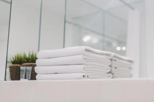una pila de toallas en un estante del baño en SleepWell Apartments en Glasgow