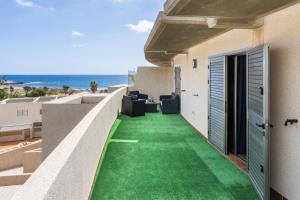 Elle dispose d'un balcon avec un sol vert et une vue sur l'océan. dans l'établissement River Vista Marina, à El Médano