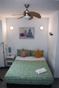a bedroom with a green bed with a ceiling fan at LOFTS ARENAL in Madrid