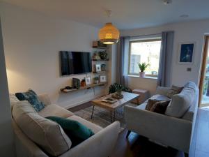 ein Wohnzimmer mit 2 Sofas und einem TV in der Unterkunft Pass the Keys Modern House by the river Free parking in Nottingham