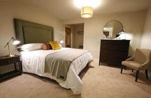 Schlafzimmer mit einem Bett, einer Kommode und einem Spiegel in der Unterkunft Sixty Six in Glenoe