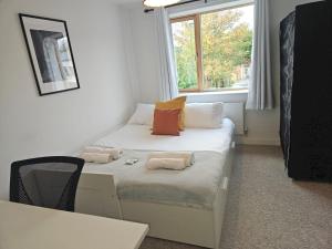 um pequeno quarto com uma cama e uma janela em Pass the Keys Modern House by the river Free parking em Nottingham