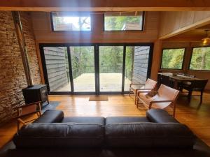 sala de estar con sofá, sillas y mesa en Mágica Casa Enclavada en el Corazón del Bosque, en Reserva Biológica Huilo Huilo