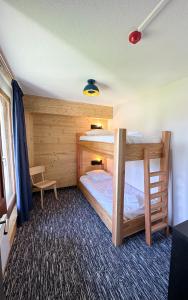 a bedroom with two bunk beds in a room at Le Motel du Gaschney in Muhlbach-sur-Munster