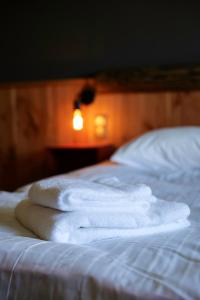 a stack of white towels sitting on a bed at Le Motel du Gaschney in Muhlbach-sur-Munster