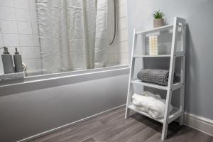 a white shelf in a bathroom with a bath tub at Century House in London