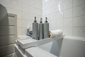 a shelf in a bathroom with three bottles at Century House in London