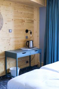 a table with a tea kettle on it in a bedroom at Le Motel du Gaschney in Muhlbach-sur-Munster