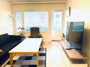 een woonkamer met een bank en een tafel bij Havi Apartment in Riihimäki